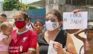 Moradora mostra cartaz com "Fora Jade" ao vivo