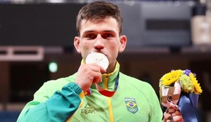 Daniel beijando a medalha de bronze nas Olimpíadas de Tóquio.