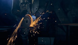 Jovem cortando com disco industria