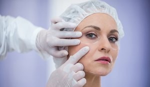 Doctor examining female patients face for cosmetic treatment