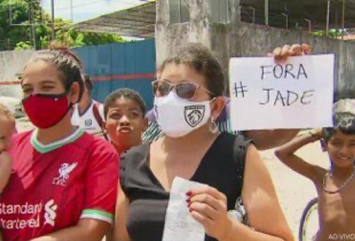 Moradora mostra cartaz com "Fora Jade" ao vivo