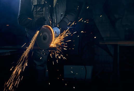 Jovem cortando com disco industria