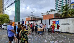 Candidatos, entre santinhos, aguardando abertura das seções eleitorais.