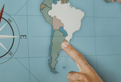 Person pointing to south america on the map