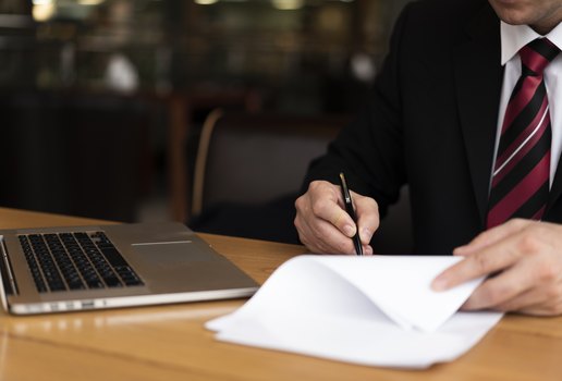 Homem no escritorio escrevendo no papel