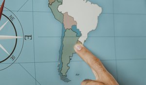 Person pointing to south america on the map