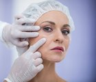 Doctor examining female patients face for cosmetic treatment