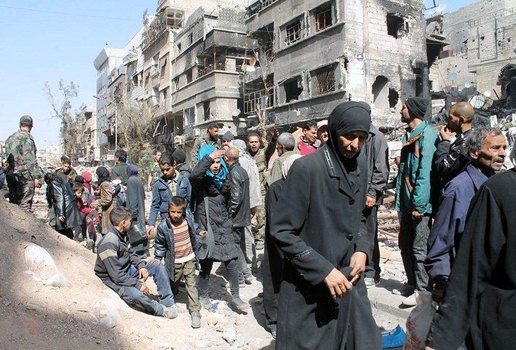 Civis recebendo ajuda na cidade de Yarmouk, na Síria