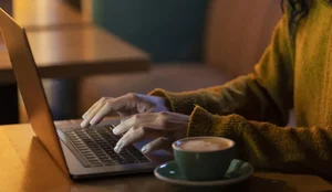 Mulher de lado trabalhando em seu laptop em uma cafeteria