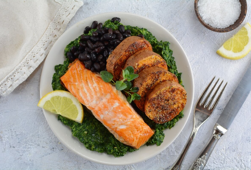 Salmão grelhado com batata-doce assada, espinafre refogado e feijão-preto (Imagem: Azra H | Shutterstock)