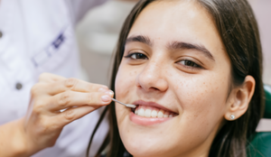Mulher sentqada na cadeira do dentista fazendo tratamento odontologico saude bucal foto ideogram