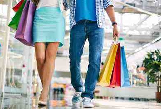 Casal caminhando ao longo shopping com sacolas de compras 1098 975