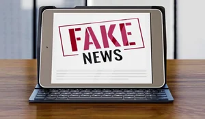 Front view laptop desk with fake news 0